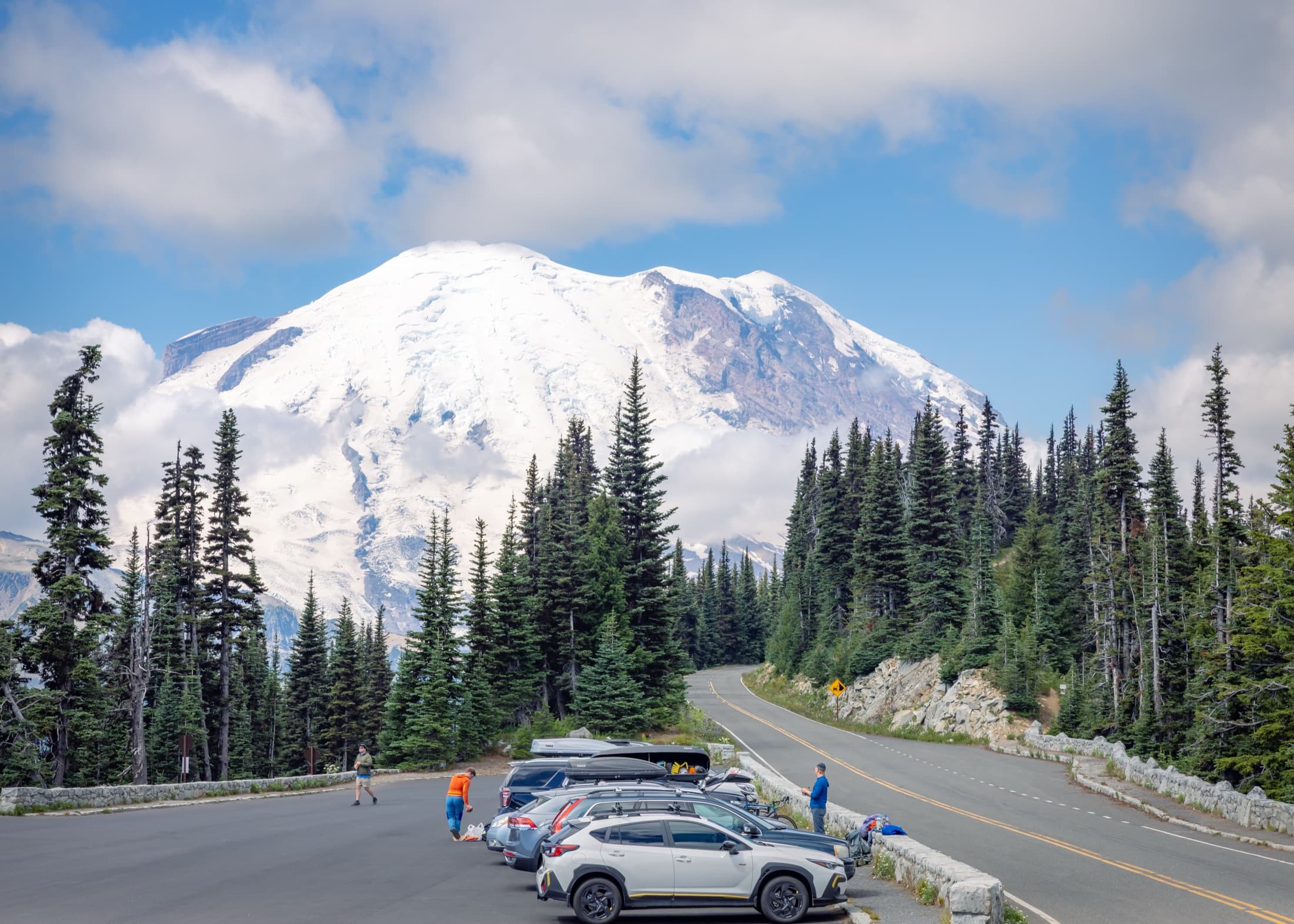 Snow-covered mountain above a forest road